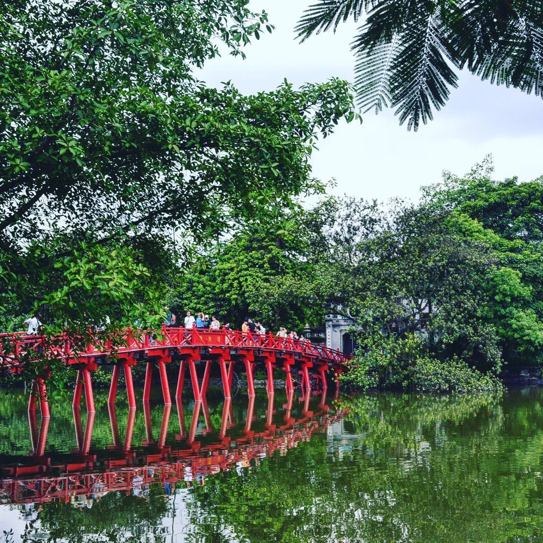 ourists-walk-across-the-huc-bridge-to-ngoc-son-temple